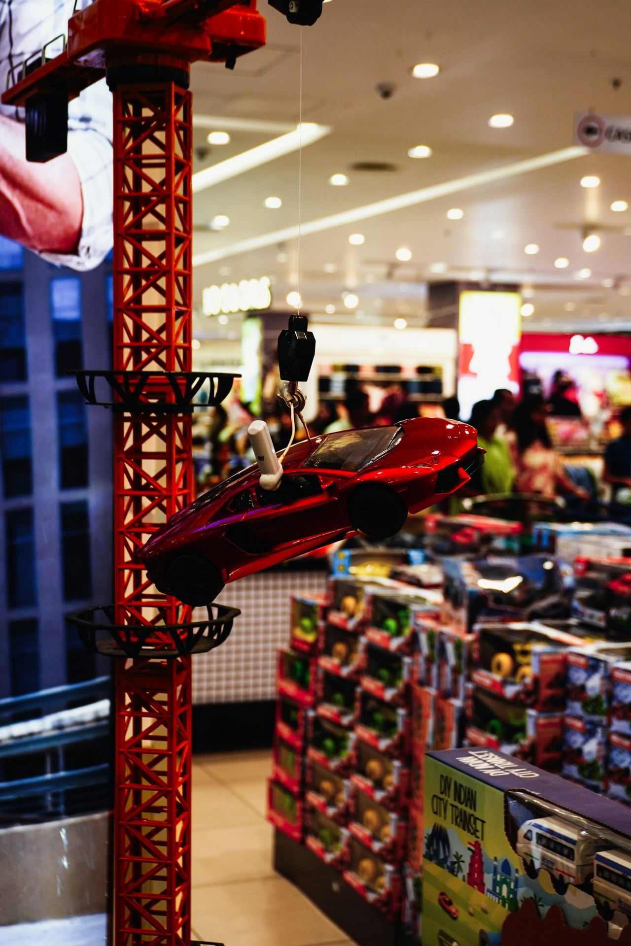 Red toy car hanging from a construction crane display